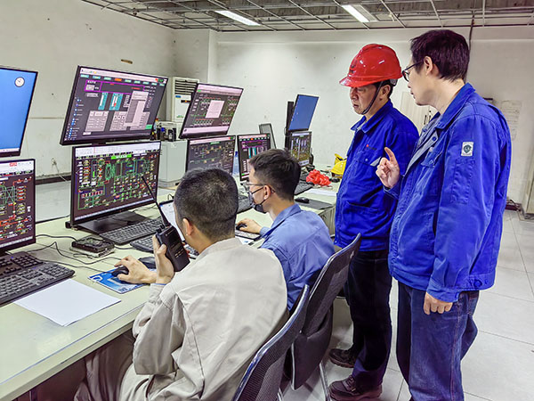 5月13日，動力車間三期鍋爐控制室，DCS改造工藝、儀表、電氣等部門聯合調試，車間主任姜軍虎與技術員畢加佳查看調試過程.jpg
